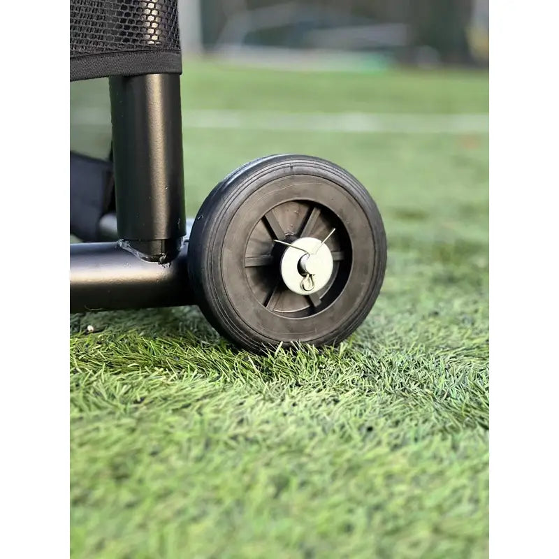 Fotballmål GIZA, nærbilde av sort plasthjul med metallfjær på svart ramme, plassert på kunstgress.