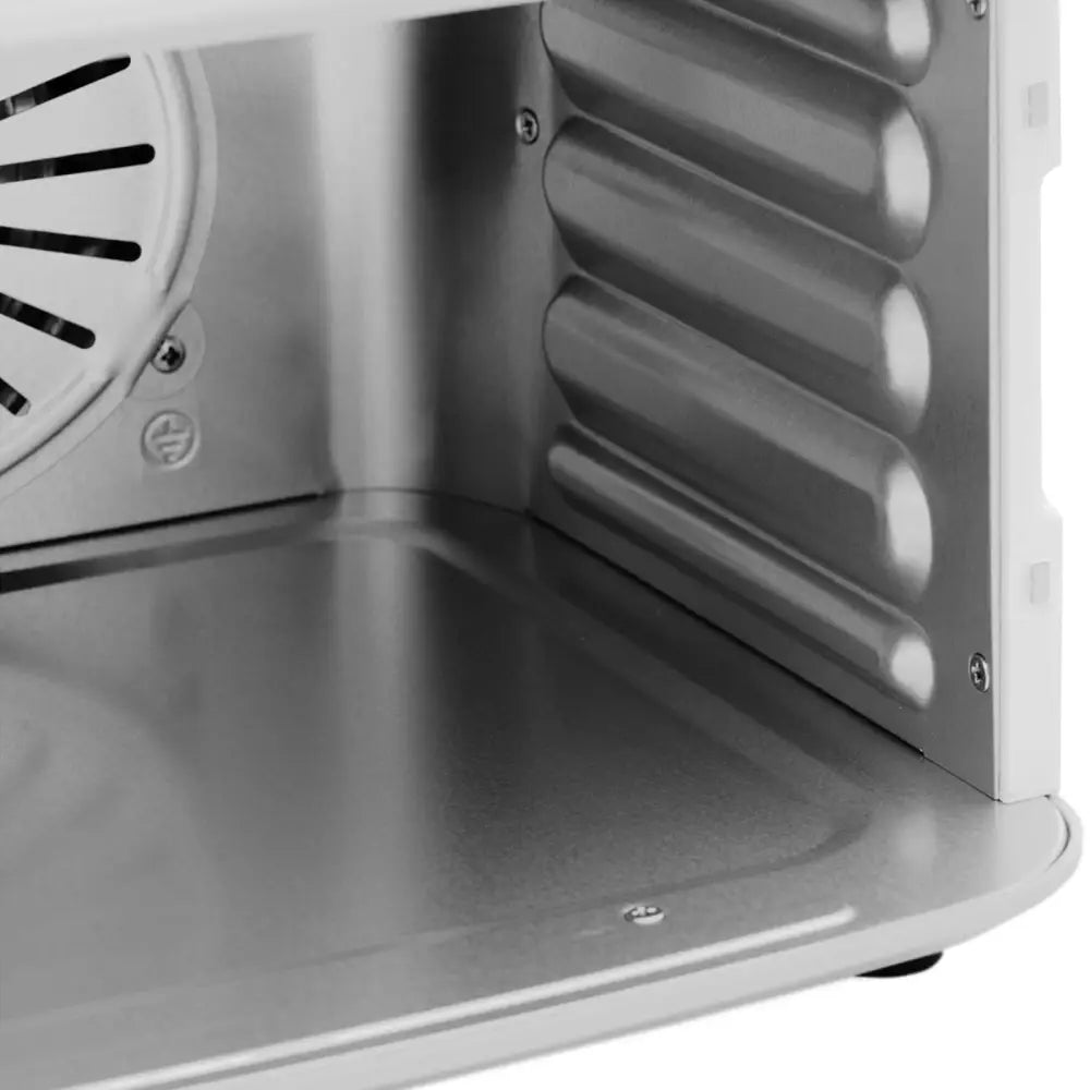 Matlufttørker detalj, innsiden med glatt metallbunn, riflet sidevegg og synlige ventilasjonsåpninger bak.