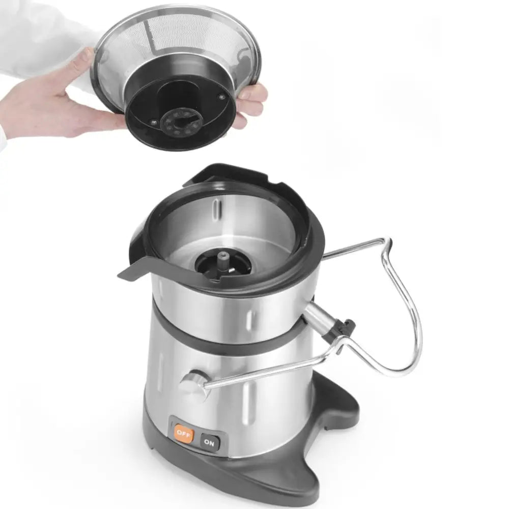 Matprosessor i børstet stål sett ovenfra, hånd løfter av filter over åpningen, av/på-knapp nederst.