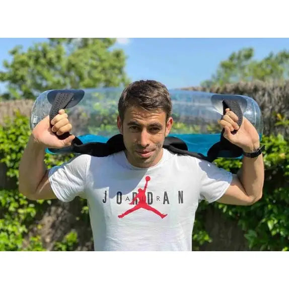 Medisinsk ball AKUAFIT BULGARIAN BAG, nærbilde av vannfylt sylinder med svarte håndtak i bruk utendørs.