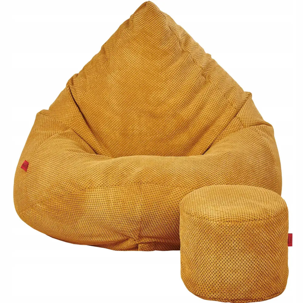 Mega saccosekk i sennepsgul plysj med grov tekstur, frontvisning sammen med rund, matchende puff.