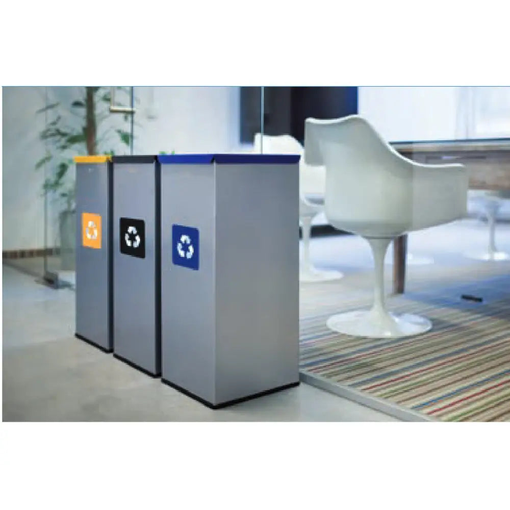 Metall avfallssorteringsbøtter med blått, oransje og svart lokk, skråvisning i moderne kontoromgivelser.