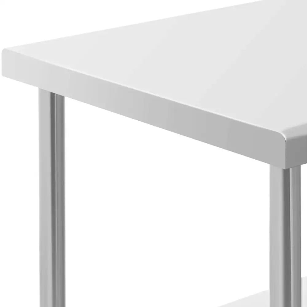 Metallisk gastronomisk rullebord, detalj av hvitt hjørne og solide ståleben sett skrått ovenfra.