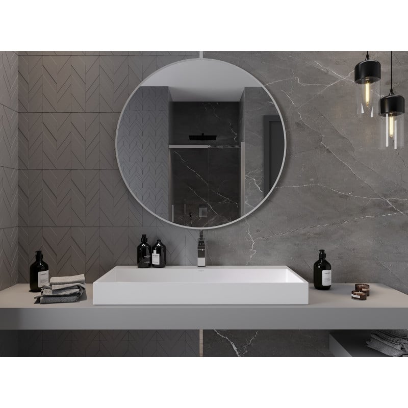 Speil til baderom rundt Mexen Loft over hvit servant med sorte såpeflasker og grå marmormønstrede fliser.