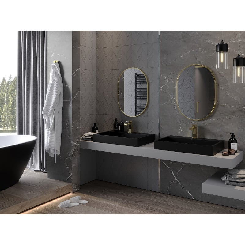 Speil baderom ovalt 70 x 50 cm med gullramme over svarte vasker og grå marmordetaljer.