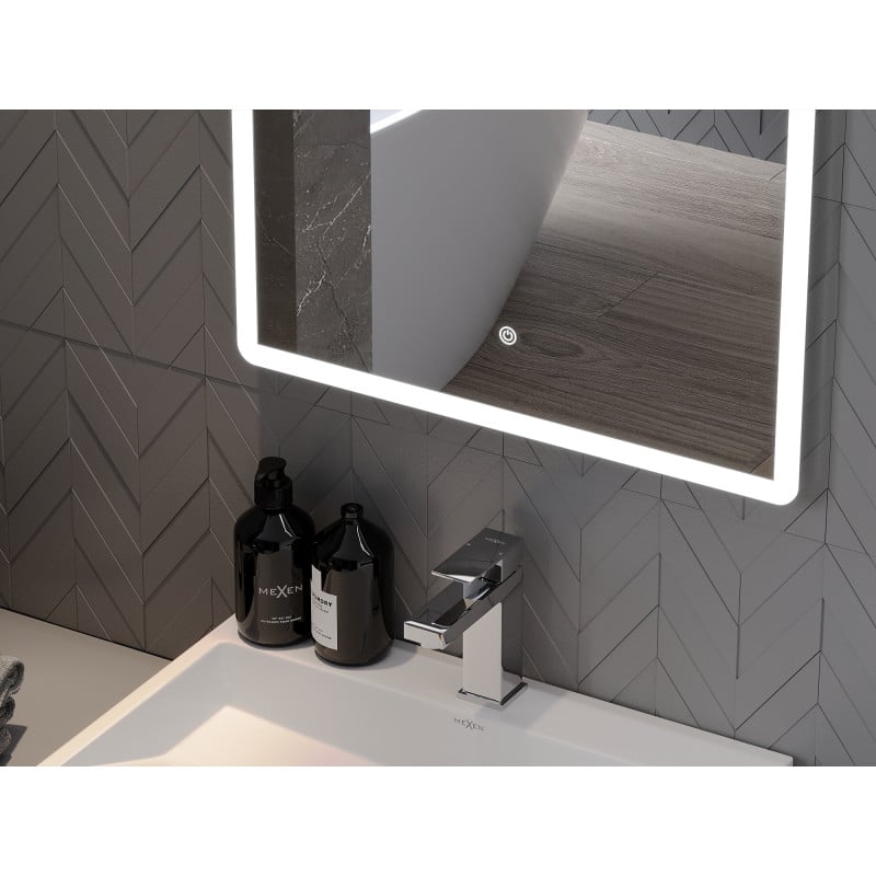 Speil til bad med integrert LED-lys over hvit baderomsvask og svarte såpedispensere mot grå fliser.