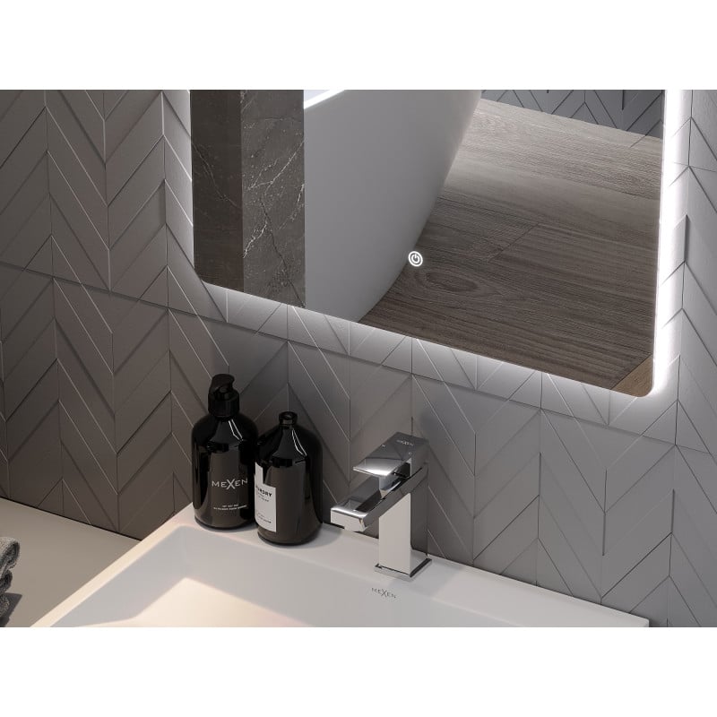 Speil til bad med LED-lys Mexen Sun reflekterer gulv og badekar over servant med kromkran og svarte flasker.