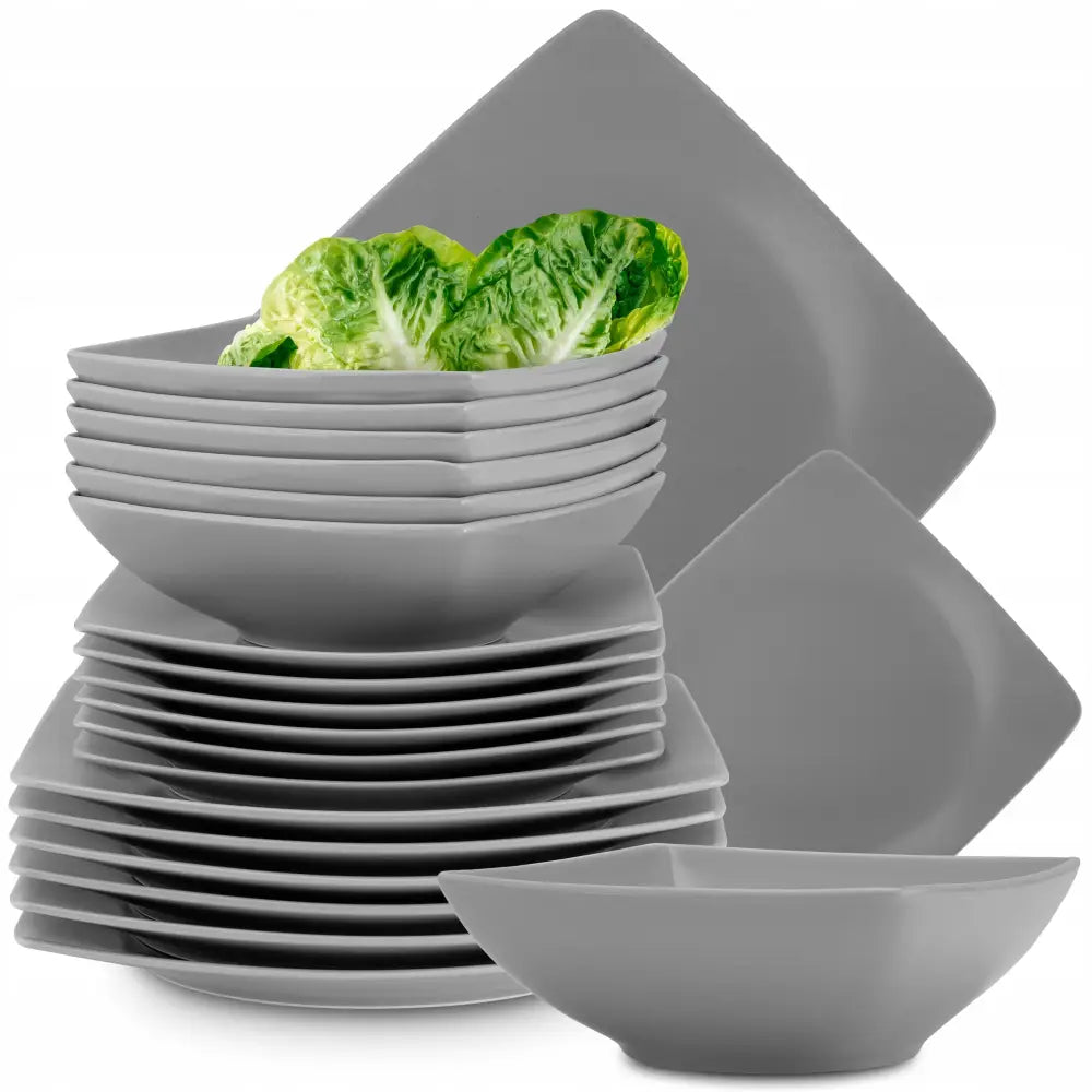 Middagsservise Epiri i matt grå porselen, stablede firkantede tallerkener og skåler med salatblader øverst.