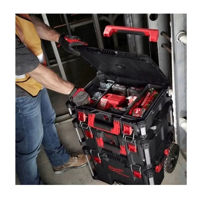 Milwaukee Packout sett, stablebar verktøykasse på hjul åpnes mens verktøy organiseres av bruker.