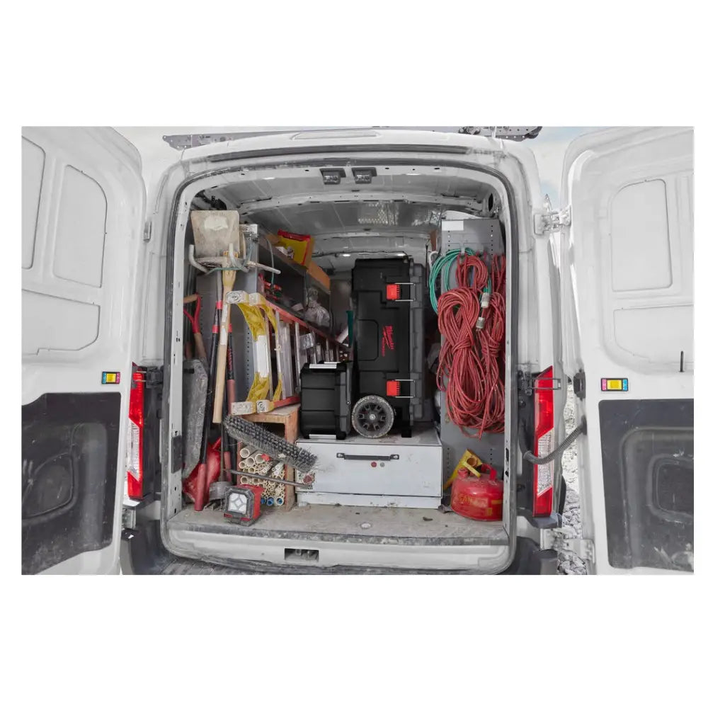 Milwaukee Packout kasse på hjul, plassert bakerst i arbeidsbil blant organisert verktøy og utstyr.