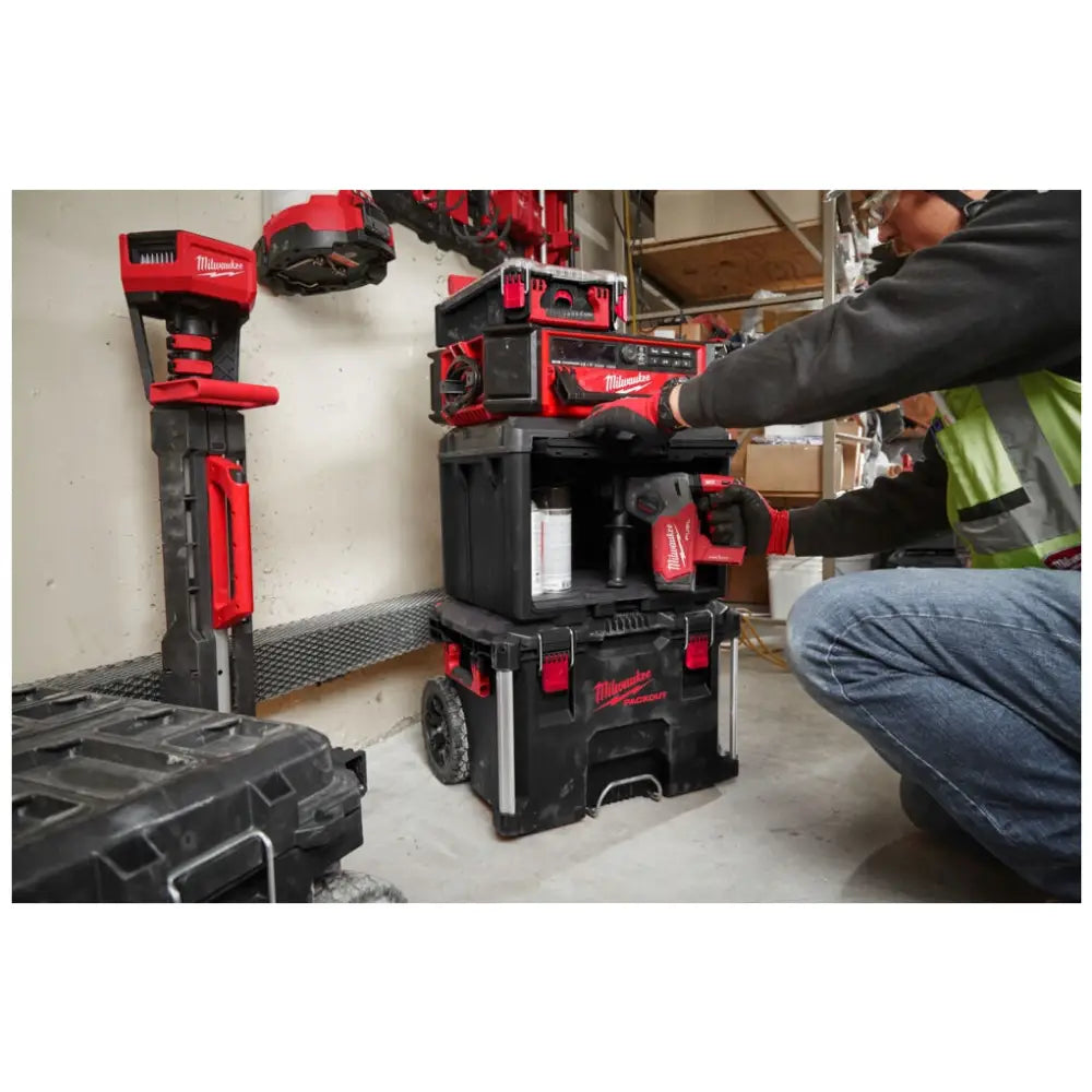 Milwaukee Packout skap, stablede kasser fra siden mens en person henter ut et elektrisk verktøy fra systemet.