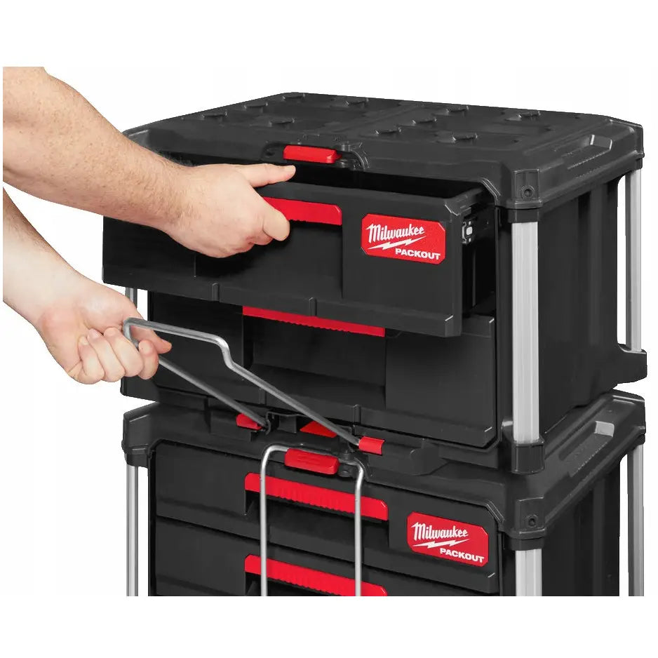 Milwaukee Packout verktøykasse, frontvisning med skuff trukket ut og hånd på håndtaket.