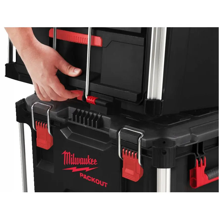 Milwaukee Packout verktøykasse, sort plast med røde detaljer, vises stablet og låses sammen av en hånd.