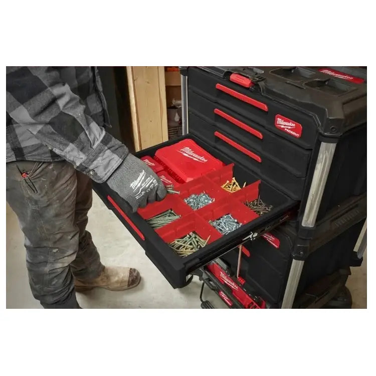 Milwaukee Packout verktøykasse med fire skuffer, åpen skuff med røde inndelere fylt med smådeler og skruer.