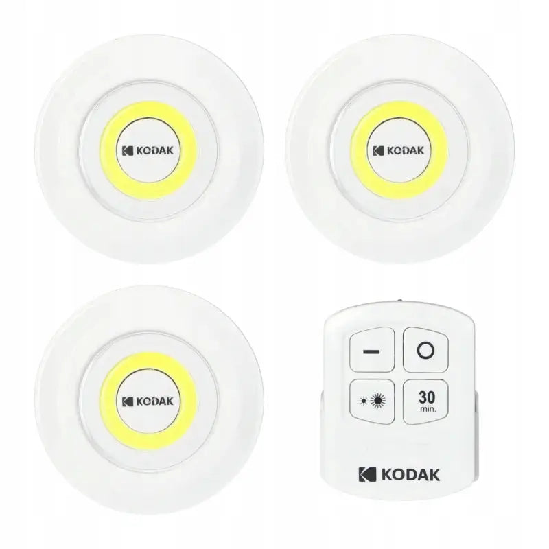 Møbellamper Kodak LED, tre hvite lamper med gul lysring og tilhørende fjernkontroll sett ovenfra.
