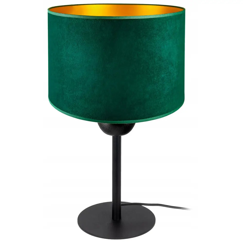 Moderne bordlampe med mørkegrønn velur-skjerm, gyllen innside og svart metallfot, sett fra skrå vinkel.