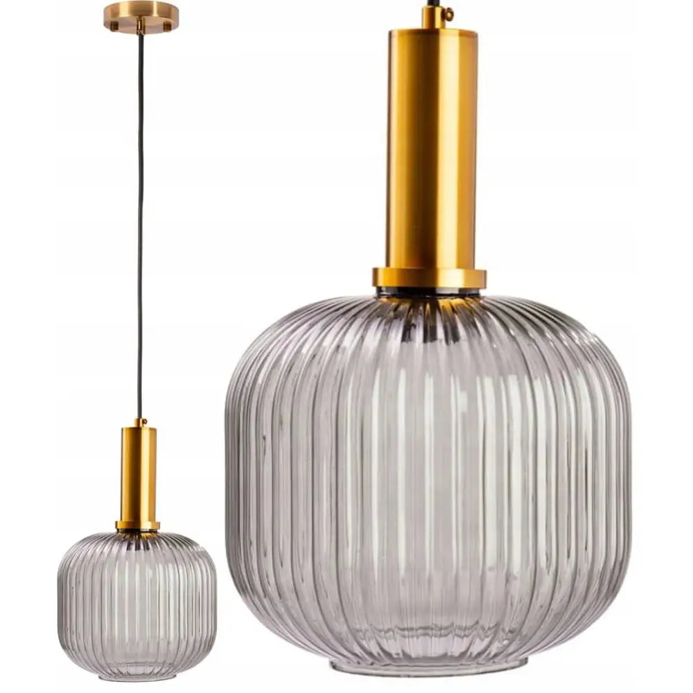 Moderne hengende lampe i rillet, klart grått glass med matt gullfarget oppheng, vist hengende fra tak.