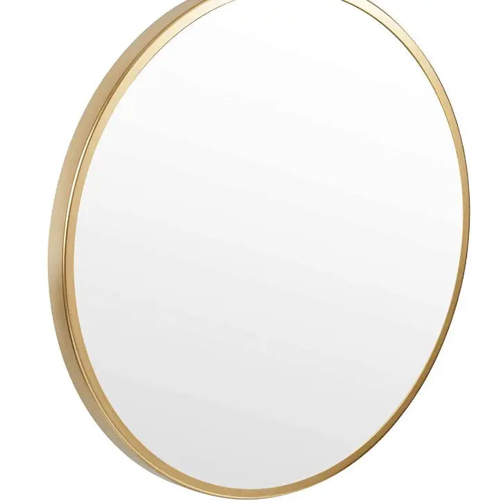 Moderne sminkebord, detalj av rundt speil med gullramme sett fra siden som fremhever metallprofilen.