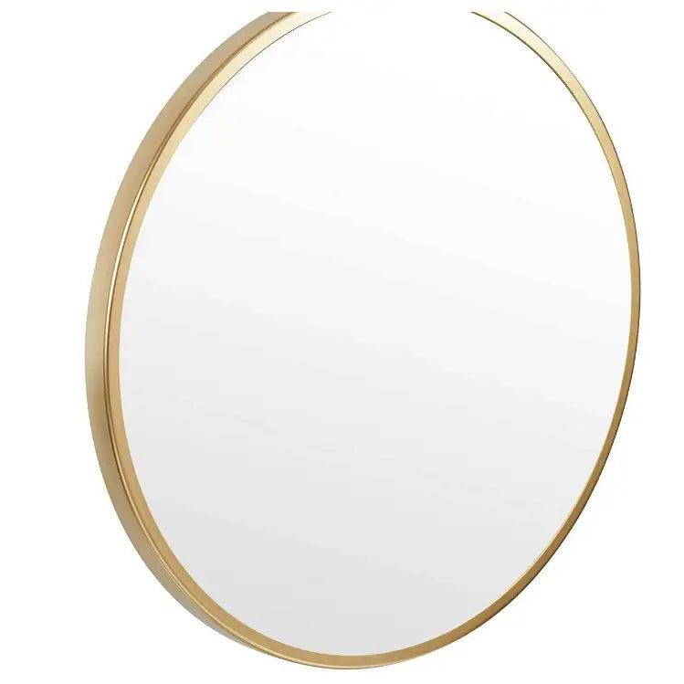Rundt sminkebordspeil med tynn gullramme, sett skrått fra høyre uten bakgrunn for tydelig detaljvisning.