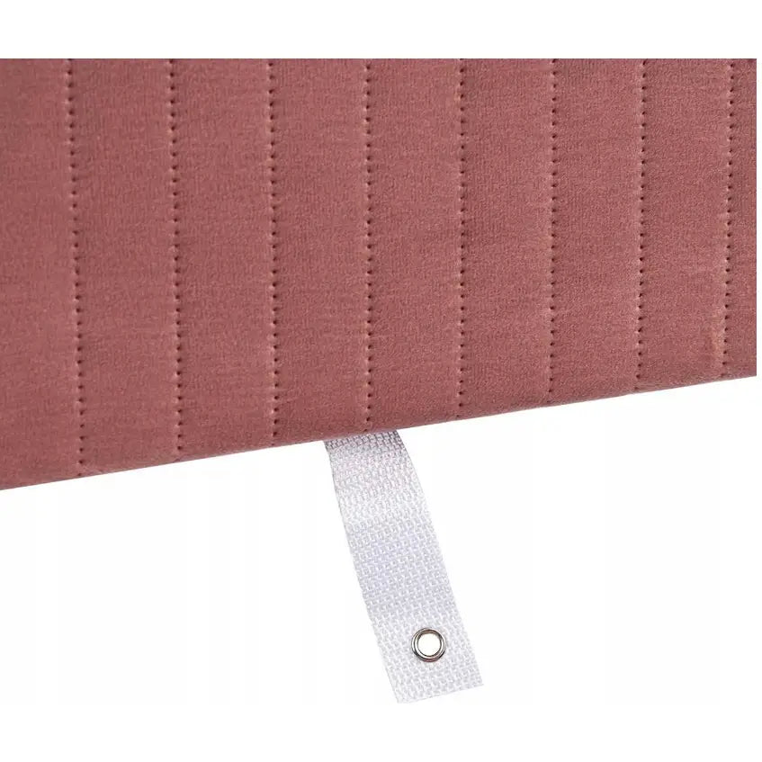 Rosa vattert tekstil med vertikale sømmer og hvit hempe med metallmalje på sminkebordkrakk.