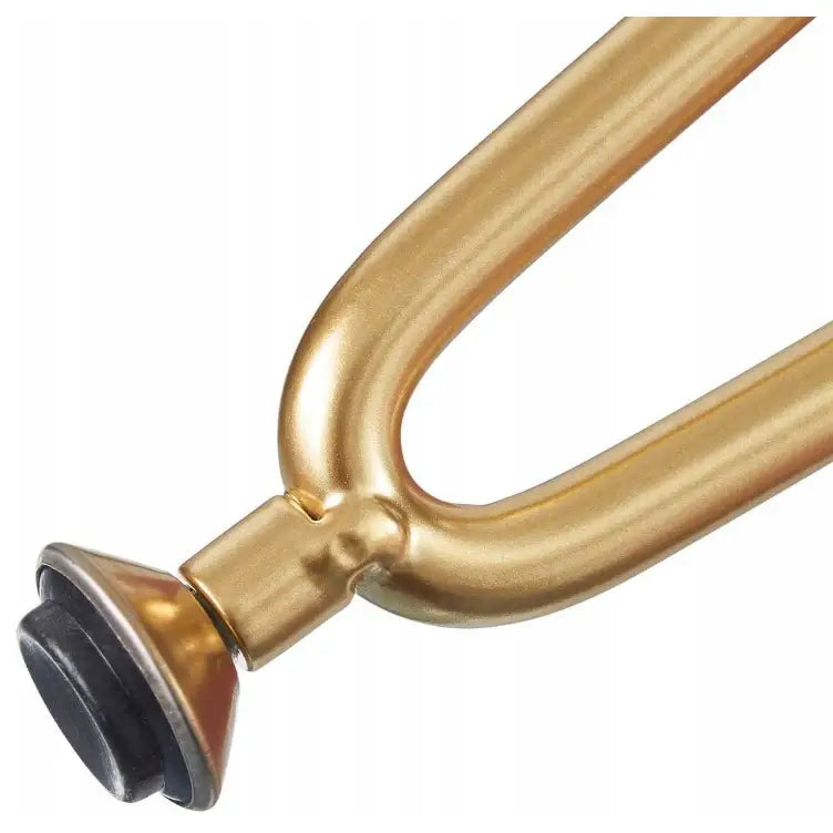 Detalj av gyllen metallfot med avrundet ende og sort gummifot, tilhørende moderne sminkebord i rosa.