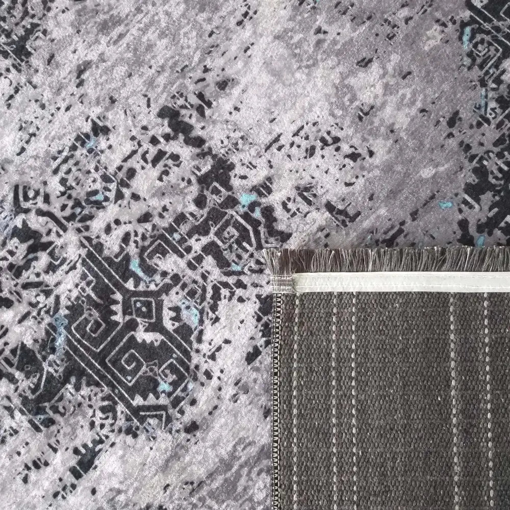 Moderne teppematte EFES 100, nærbilde av abstrakt mønster, brettet hjørne og dekorative frynser.