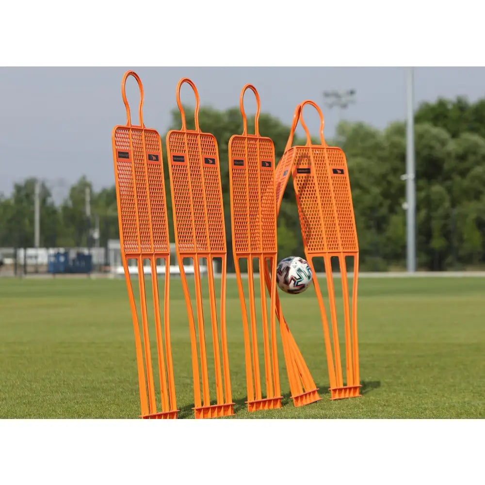 Mur Fotball PRO 180 cm, fire oransje treningsfigurer i nylon på gressbane, én bøyes av balltreff.