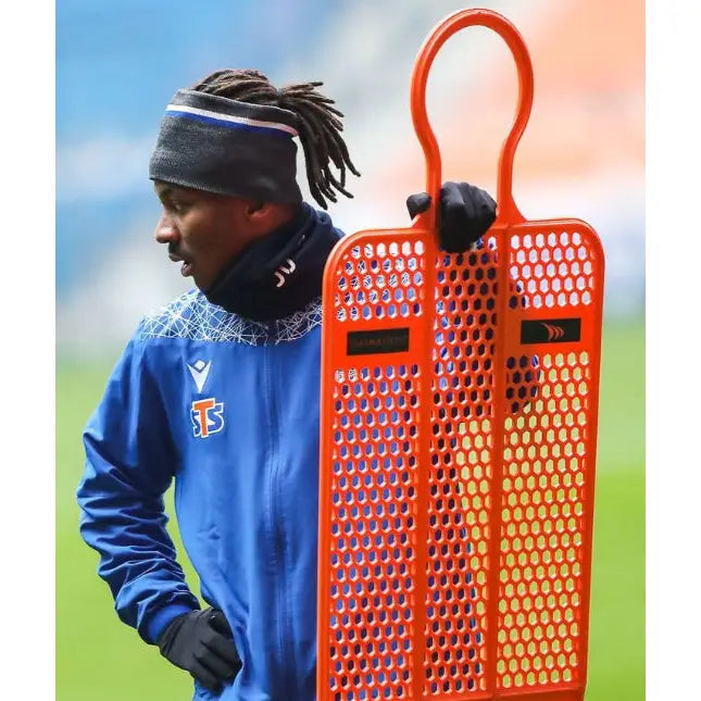 Mur Fotball PRO 180 cm, oransje treningsfigur med hull, holdes sidelengs av person på fotballbane.