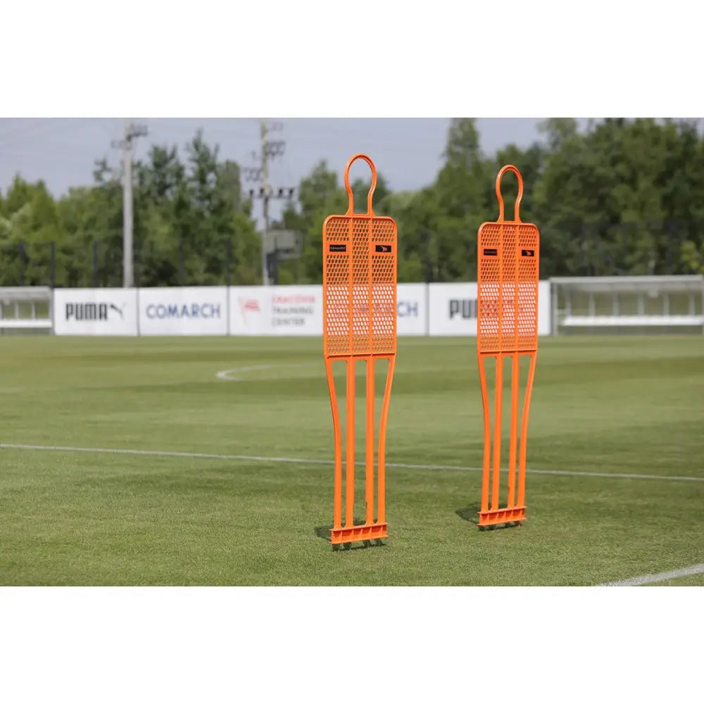 Mur Fotball PRO 180 cm, to oransje treningsfigurer i plast på gress, sett skrått forfra under fotballøkt.