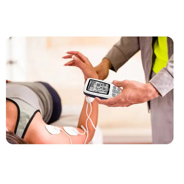 Muskelstimulator i bruk, elektroder festet på overarmen mens en annen person holder den hvite enheten.