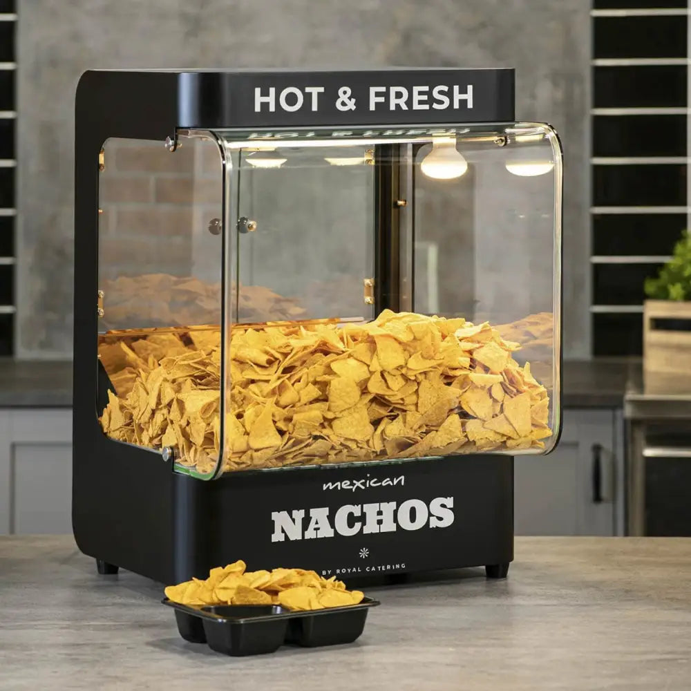 Nachos maskinvarmer i svart metall og glass, sett fra siden med opplyste chips i skuff på kjøkkenbenk.