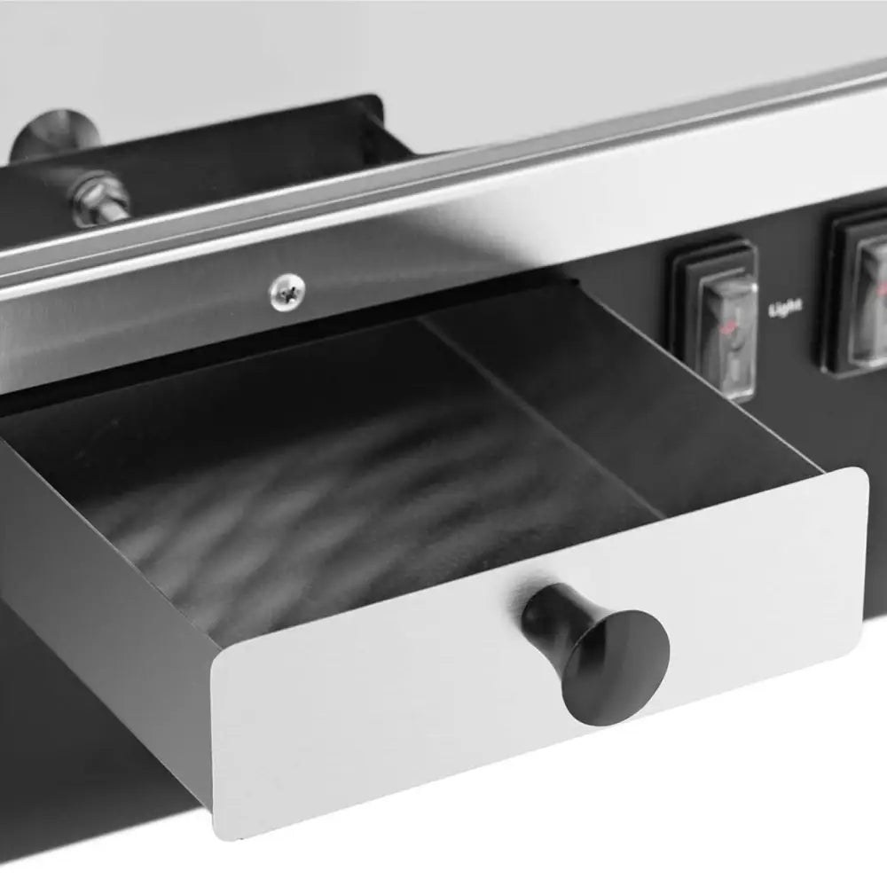 Nachos maskinvarmer med metallbrett halvt ute, fokus på sort håndtak og sølv kontrollpanel med brytere.