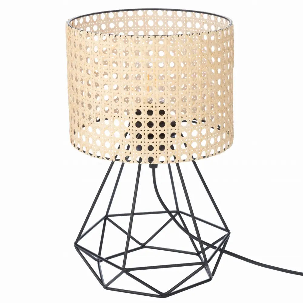 Nattlampe med sort metallstativ og sylinderformet rattanskjerm, sett fra skrå vinkel med synlig ledning.