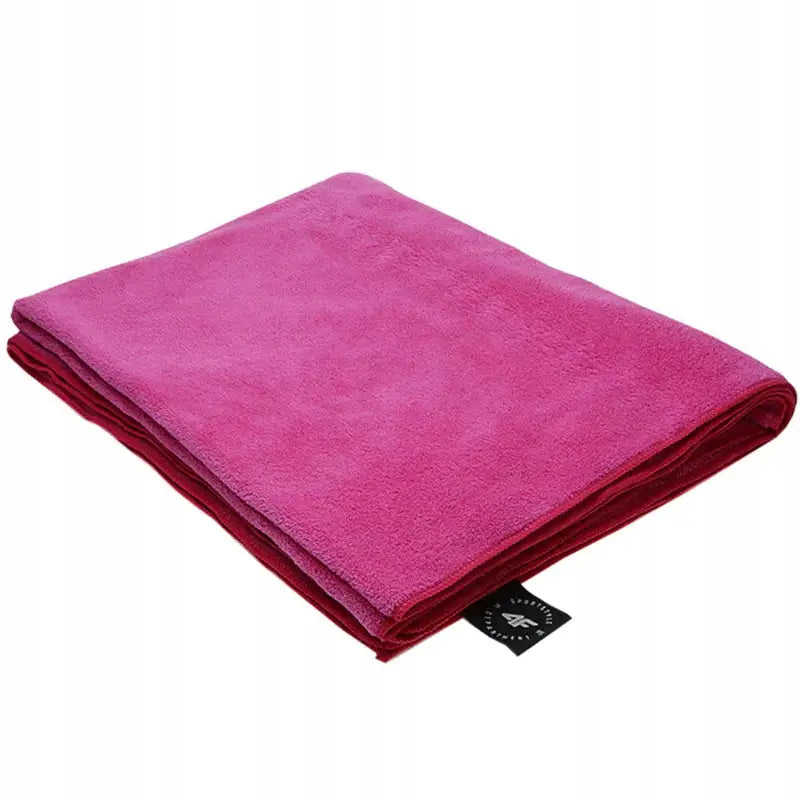 Mikrofiber håndkle i fuchsia, sammenbrettet med synlig svart merkelapp langs kanten.