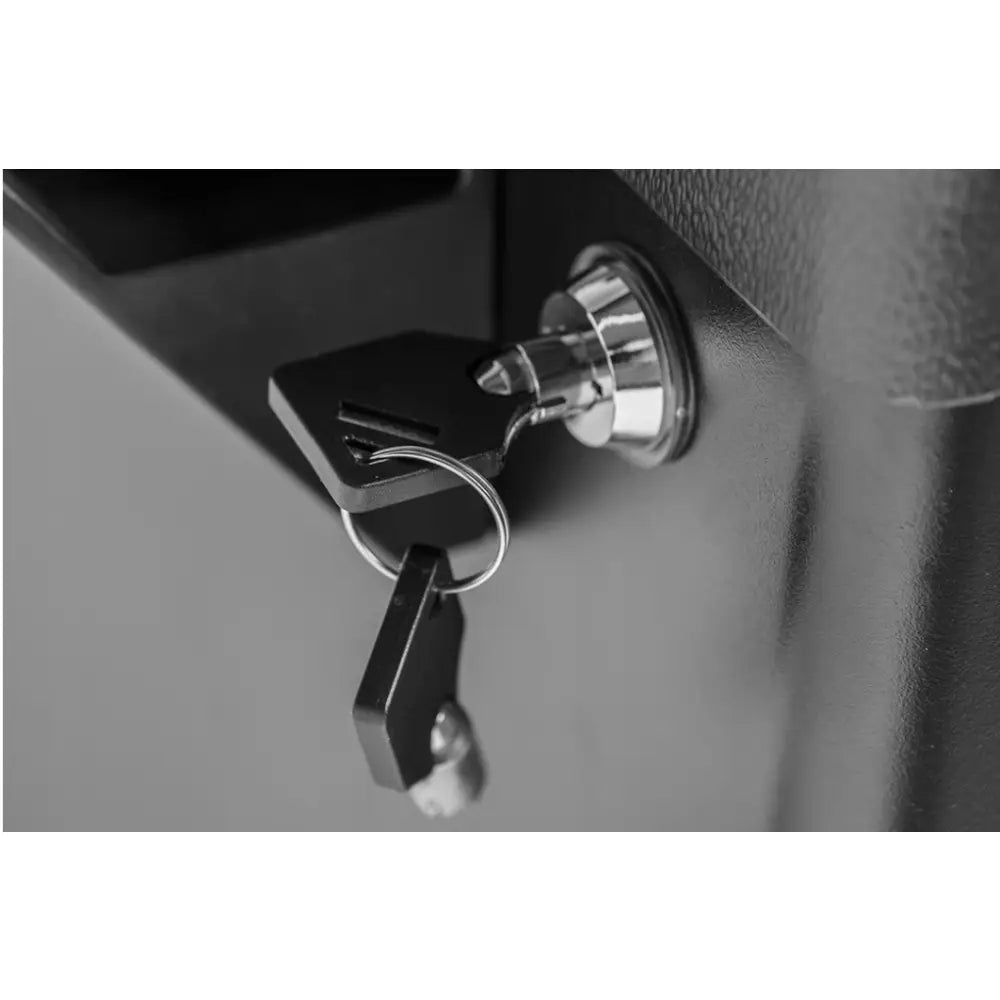 Neo Verktøyskap, nærbilde av blank metall-lås med svart nøkkel i nøkkelring mot matt, mørk overflate.