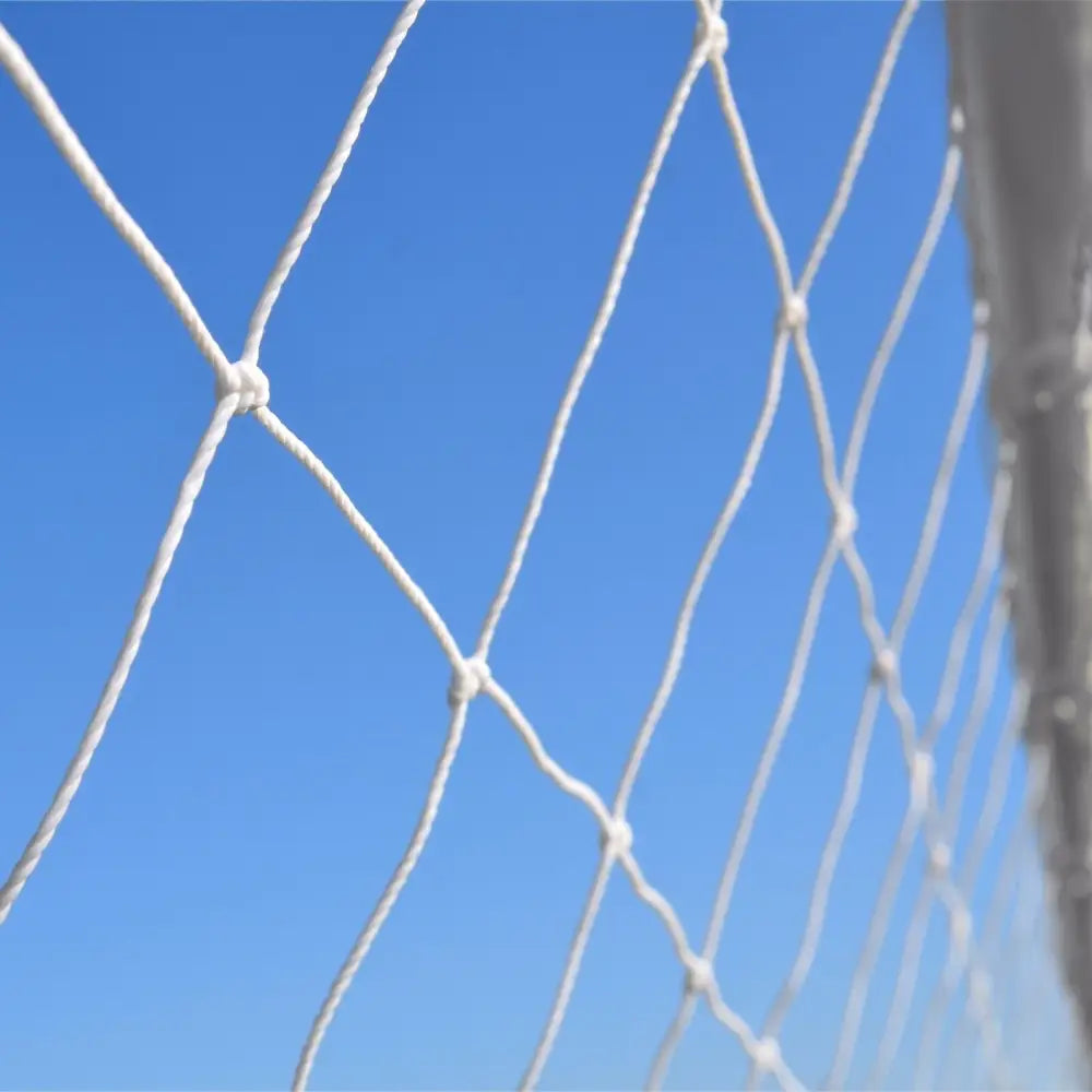 Nettbrettholder for fotball, nærbilde av hvitt tauverk med knuter mot blå himmel.