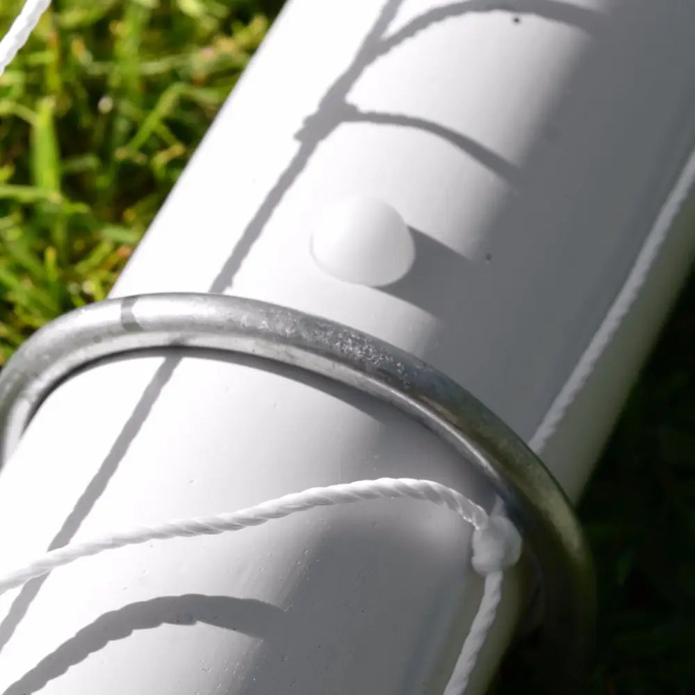 Nettbrettholder for fotballmål, nærbilde av hvit stang med metallring, snor og synlige skruedetaljer på gress.