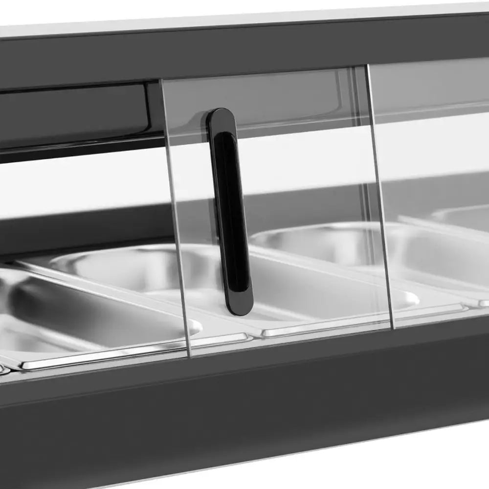 Nærbilde av sort håndtak på glasskyvedør til kjøleromsdisk, stålfargede beholdere bak glasset.