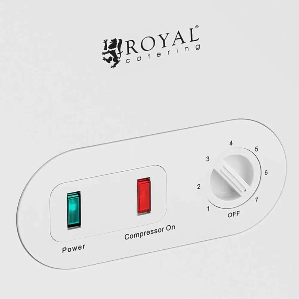 Detaljbilde av kontrollpanel på fryseboks med grønn og rød indikator og hvit temperaturbryter med tall.