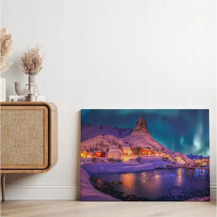 Norsk vinter og nordlys lerretsbilde, plassert mot gulvet ved et lyst trebord med dekorative vaser.