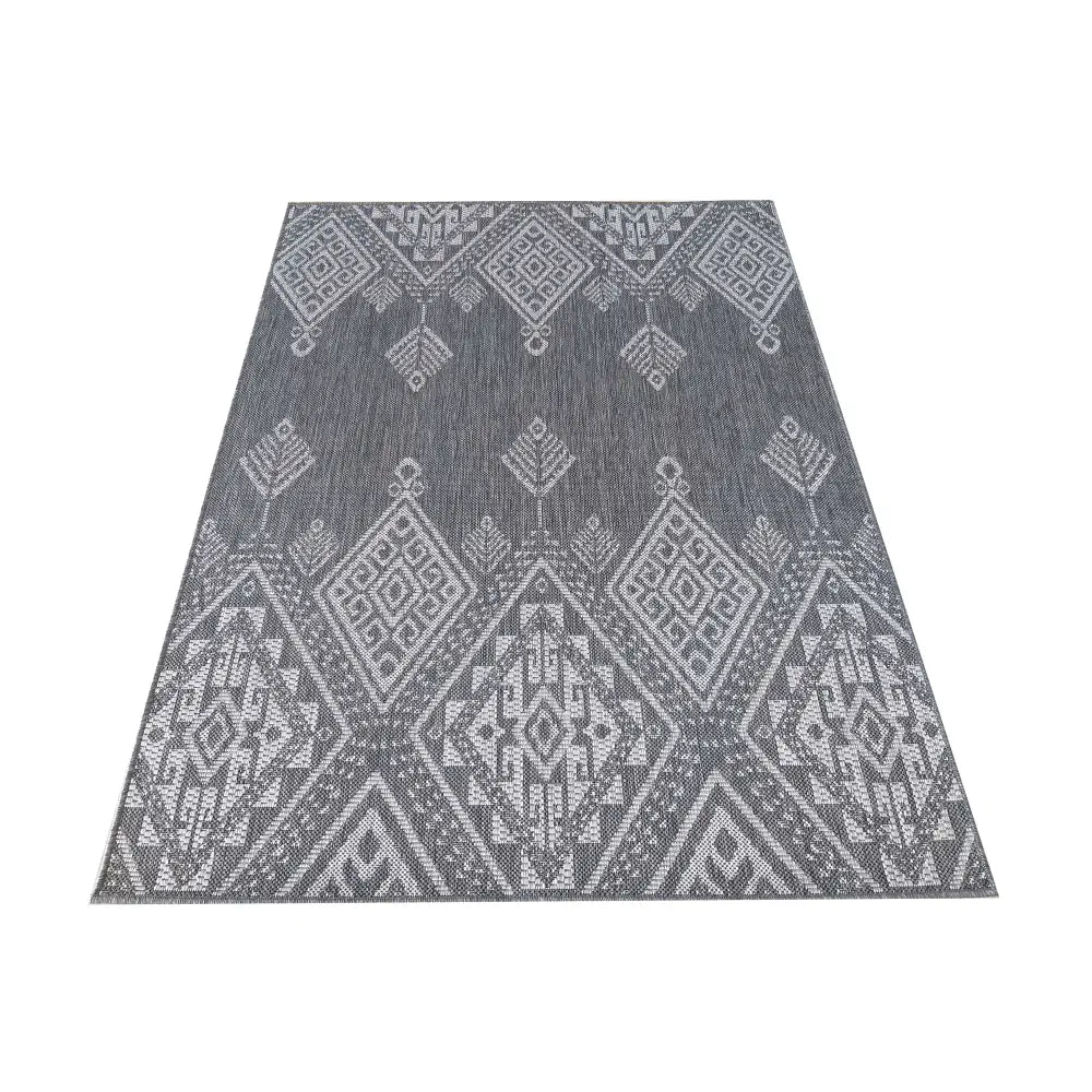 Grått og hvitt Zara-teppe 120x170 cm, sett ovenfra med store diamant- og trekantmønstre i flattvevd tekstur.