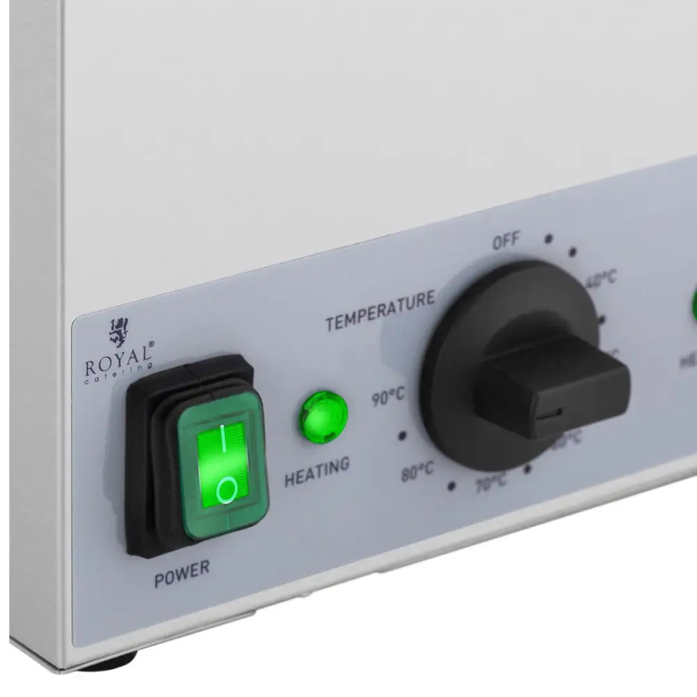 Oppvarmingsenhet for sauser, nærbilde av kontrollpanel med grønn bryter, indikatorlys og sort temperaturvelger.