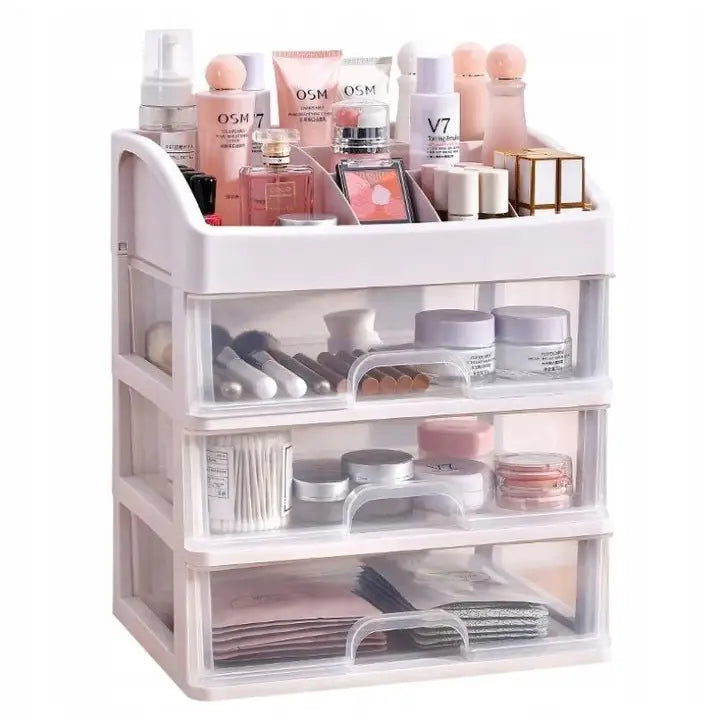 Organizer for kosmetikk, hvit boks med tre gjennomsiktige skuffer fylt med sminke og hudpleie, sett fra skrå vinkel.