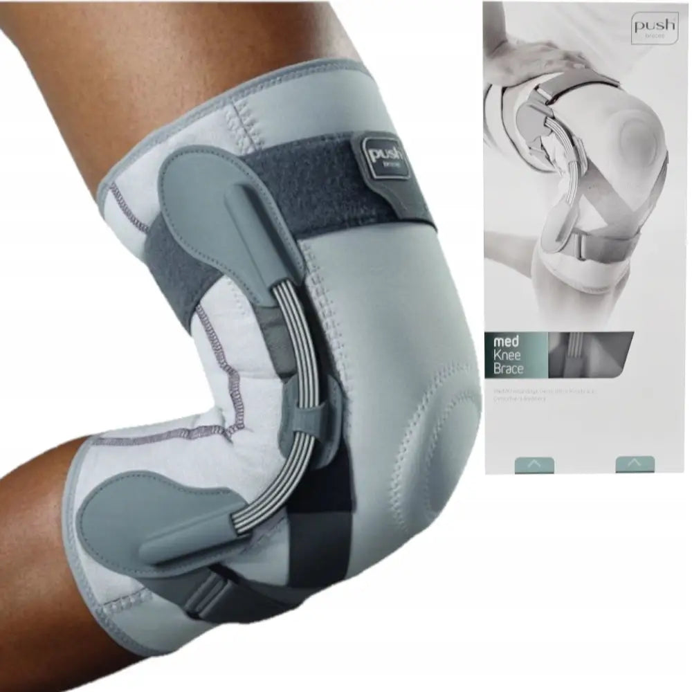 Ortese Stabilisator Knebind Push, sidevisning på bøyd kne med synlige sidestøtter og produkteske i bakgrunnen.