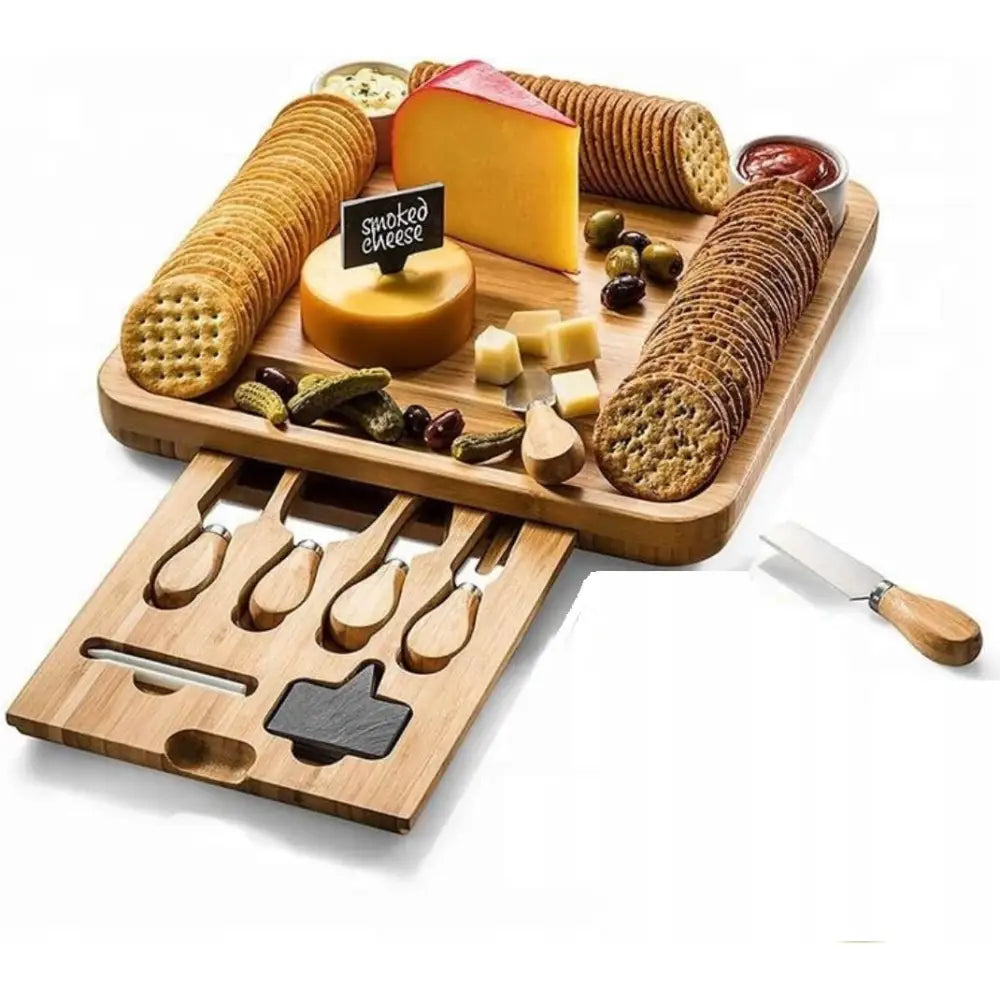 Osteserveringsbrett i lyst tre med variert ost, kjeks, oliven, pickles og synlig uttrekksskuff med kniver.