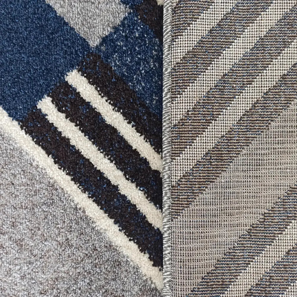 Otto Moderne teppe 240 x 330 cm, nærbilde av flerfargede felt, vevet underside og forsterket kant.