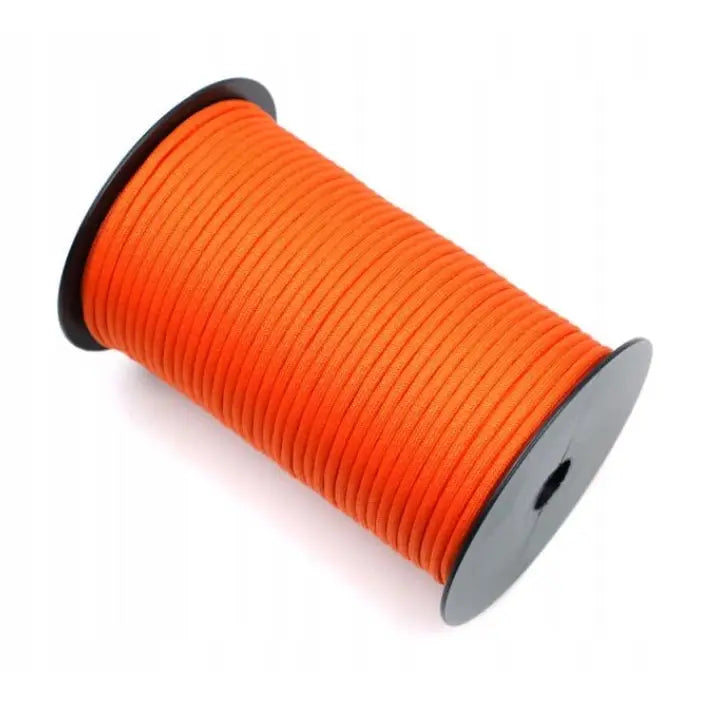 Paracord 550 flintfarget tau, oransje flette rullet tett på svart spole, sett fra skrå vinkel.