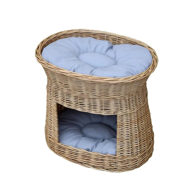 Pilhytte Pilhytte Rede i flettet naturmateriale med lyseblå pute på taket og en inni åpningen foran.