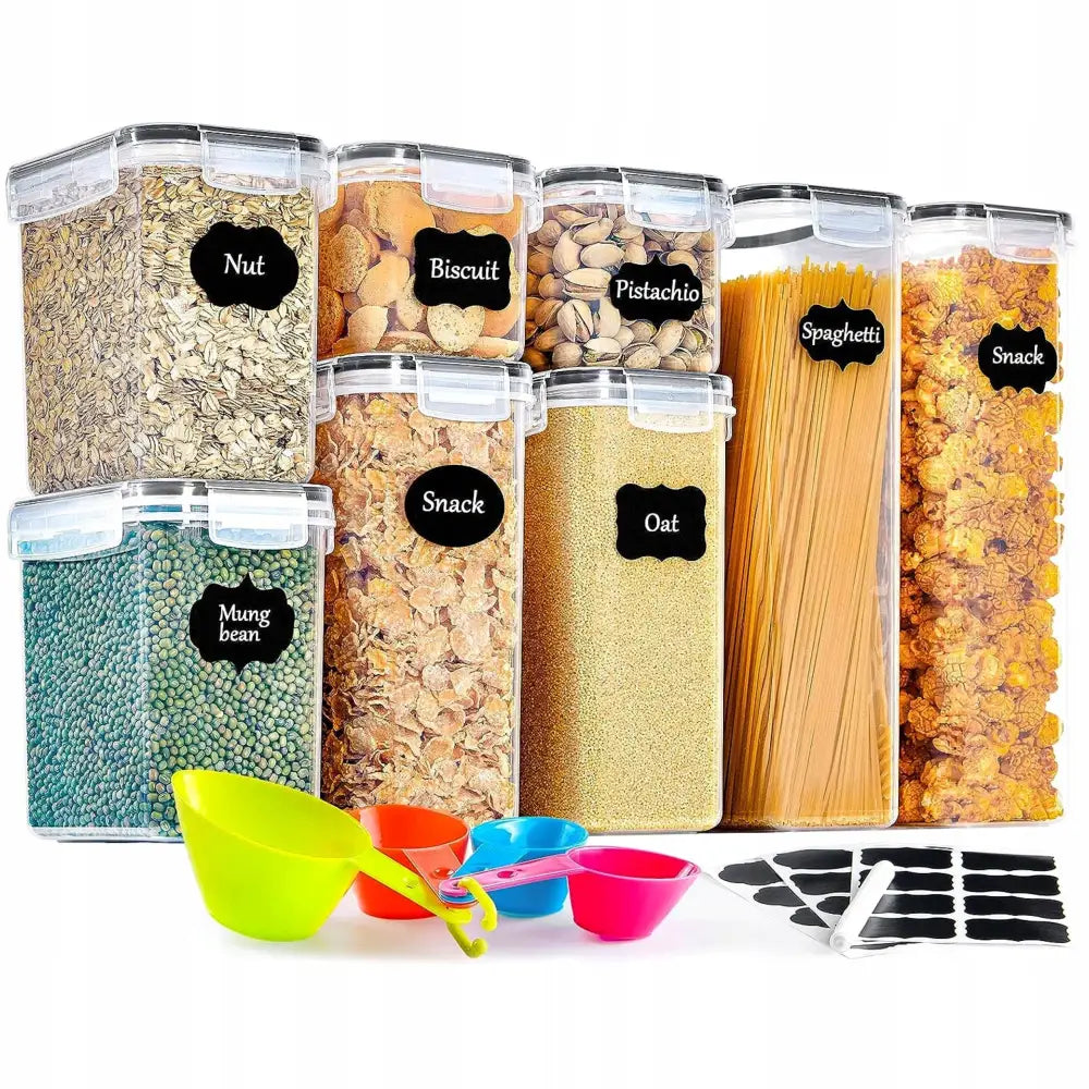 Plastbeholdere for mat, syv bokser fylt med ulike matvarer, målebeger, etiketter og hvit penn foran.