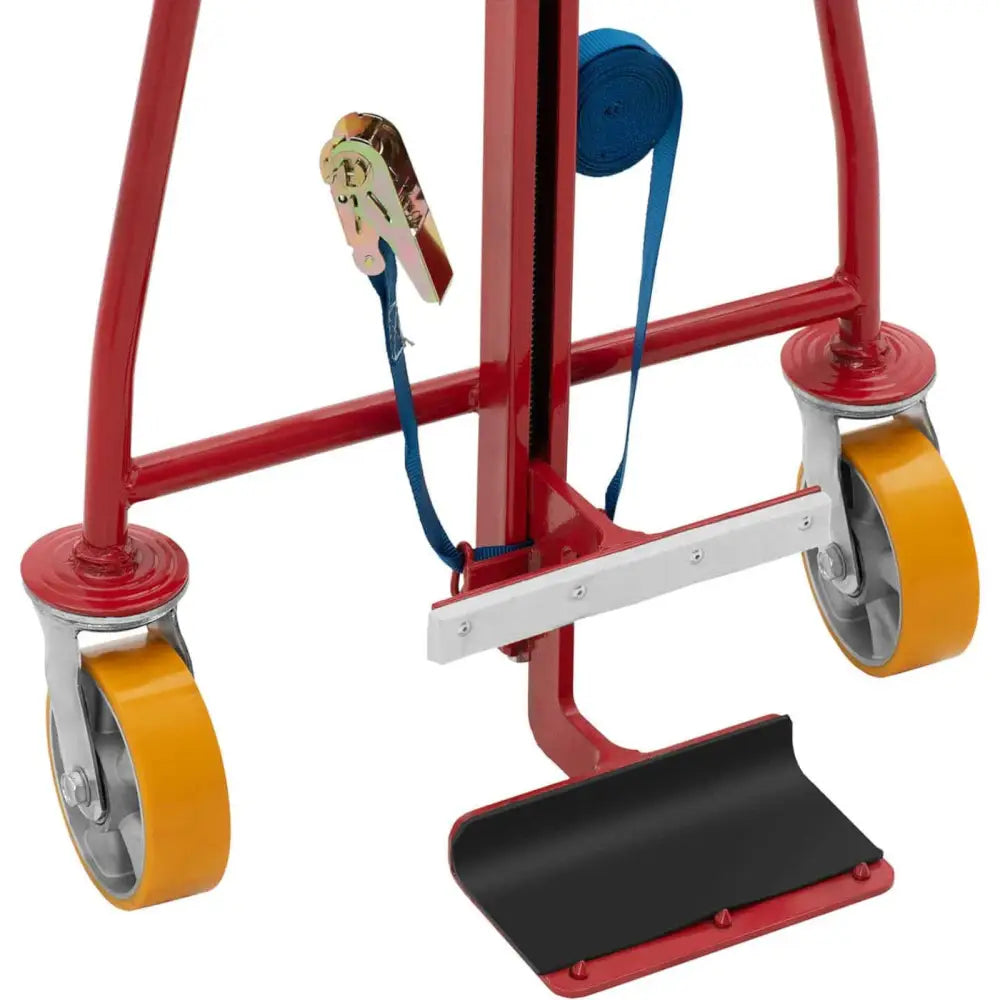 Plattformvogn med rød ramme, gule hjul, svart lasteplate og blå stropp med spennemekanisme, sidevisning.